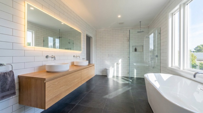 Salle de bain entièrement rénovée : double vasque sur meuble bois et baignoire îlot